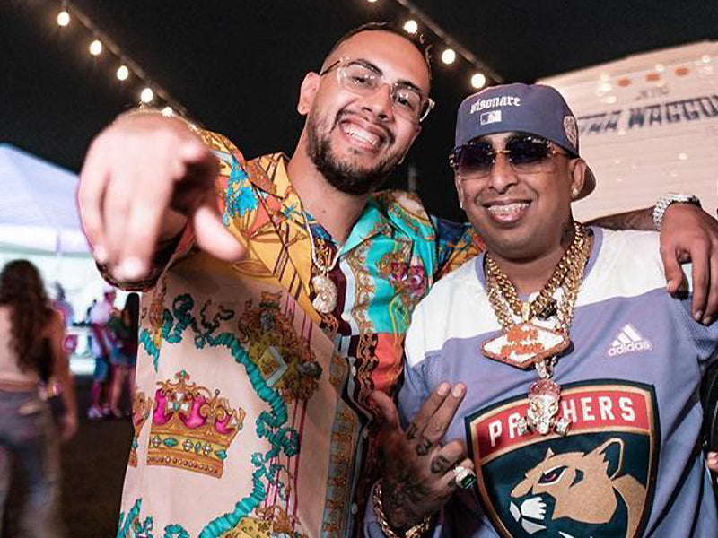 Dos hombres con cadenas de oro gruesas y brillantes con dijes grandes estilo hip hop.