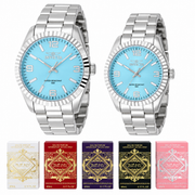 Pareja Invicta 48904 y 48905 con relojes plateados de esferas azul claro y cinco cajas de mini perfumes Lattafa, separados sobre fondo blanco.